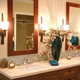 This is a picture in a bathroom of a double sink vanities with mirrors and lights